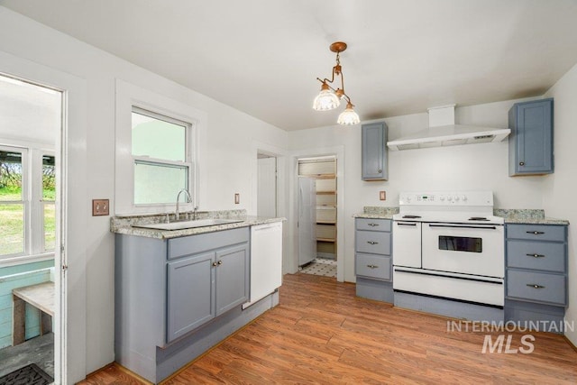 1045 N Beech Rd, Genesee, ID 83832 - kitchen featuring a sink, wall chimney range hood, white appliances, light wood-style flooring, and gray cabinetry