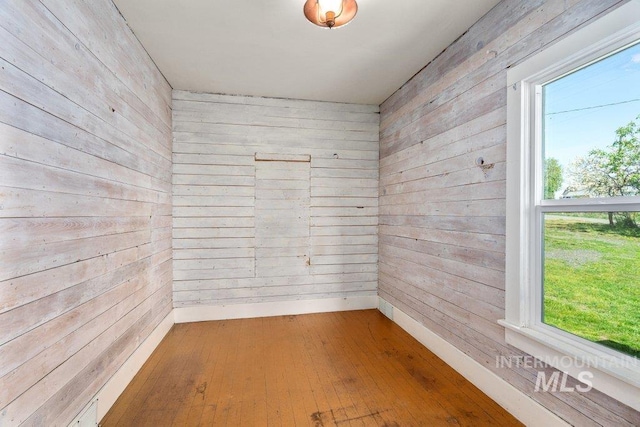 1045 N Beech Rd, Genesee, ID 83832 - spare room featuring baseboards, wooden walls, and hardwood / wood-style floors