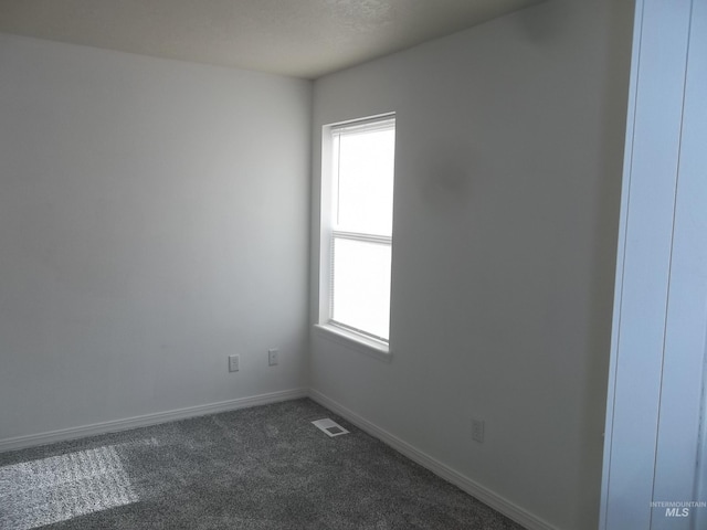 unfurnished room featuring dark carpet