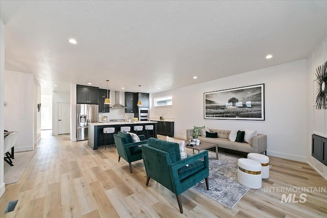 living room with light hardwood / wood-style flooring and a textured ceiling