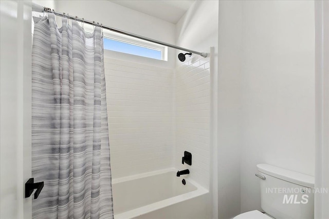 bathroom featuring shower / tub combo and toilet