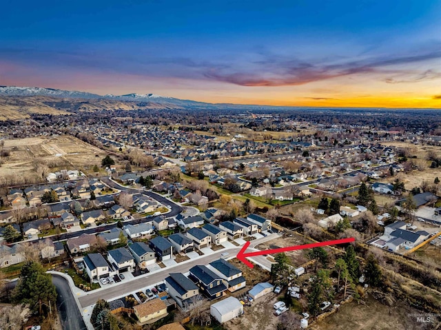 aerial view at dusk featuring a mountain view