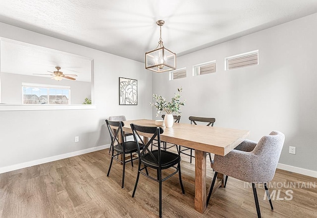 dining room featuring ceiling fan, baseboards, and wood finished floors