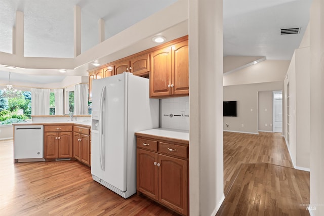 1728 S Labrador Pl, Meridian, ID 83642 - kitchen with white appliances, light wood finished floors, light countertops, a peninsula, and lofted ceiling