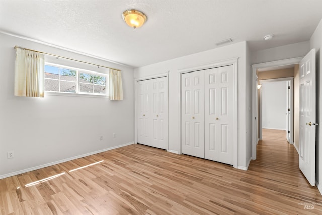 1728 S Labrador Pl, Meridian, ID 83642 - unfurnished bedroom with two closets and light wood-type flooring
