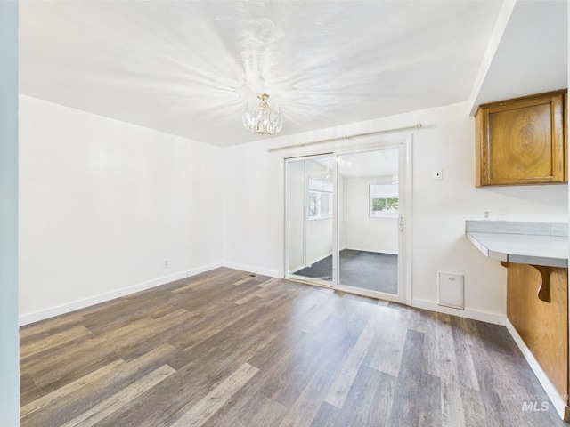 1409 Blane, Emmett, ID 83617 - unfurnished dining area with a chandelier, dark wood-style flooring, and baseboards