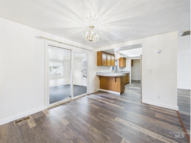 1409 Blane, Emmett, ID 83617 - kitchen with brown cabinetry, dark wood finished floors, a chandelier, baseboards, and a peninsula