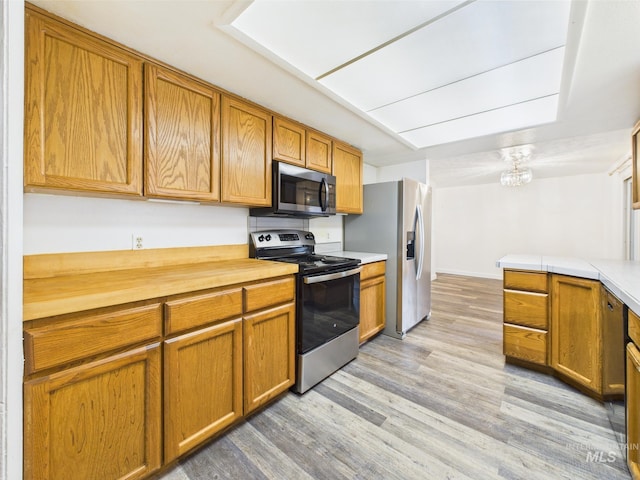 1409 Blane, Emmett, ID 83617 - kitchen featuring appliances with stainless steel finishes, brown cabinets, and light wood finished floors