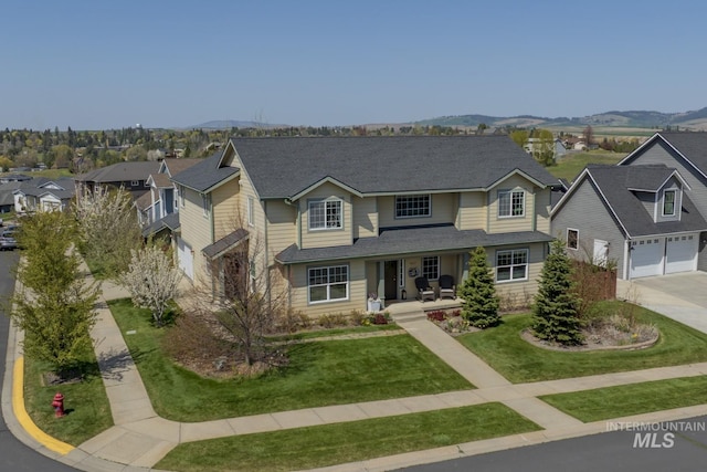 traditional-style home with covered porch, a front yard, concrete driveway, a mountain view, and a residential view
