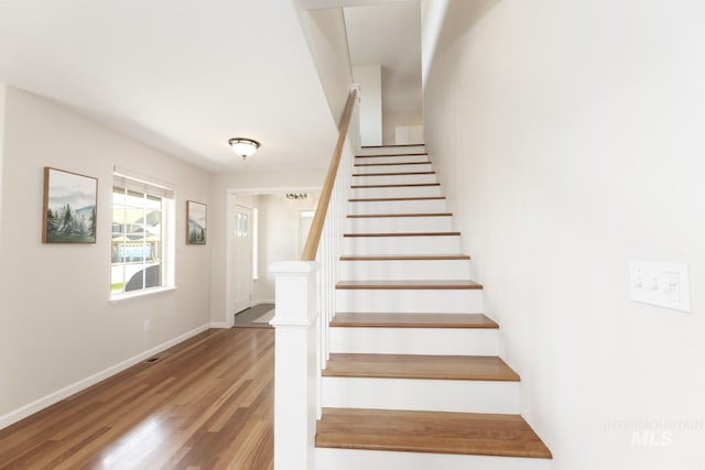 stairs with baseboards and wood finished floors