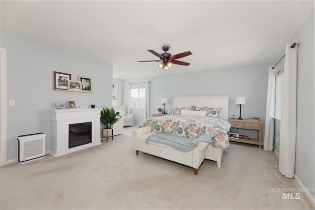 bedroom featuring baseboards, ceiling fan, and light carpet