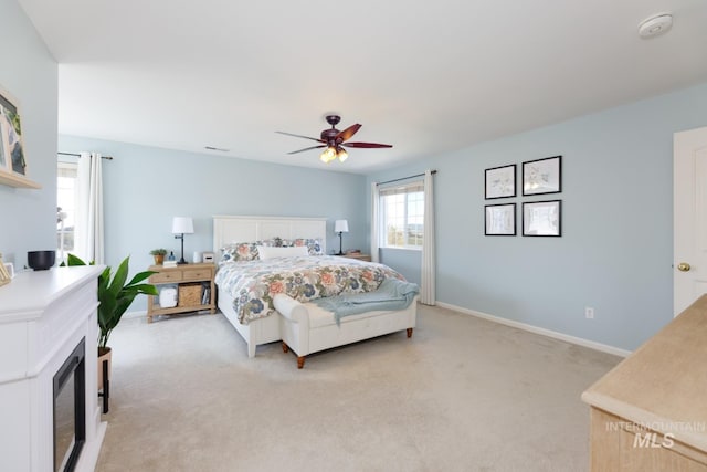 bedroom featuring baseboards, ceiling fan, and light carpet