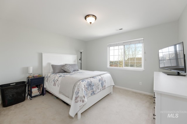 bedroom featuring baseboards, light carpet, and visible vents
