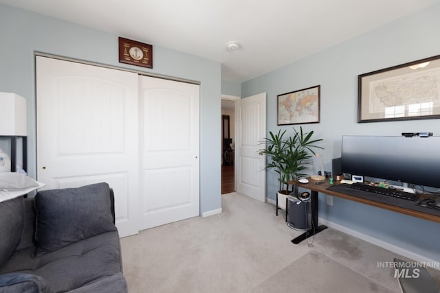 office with baseboards and light colored carpet