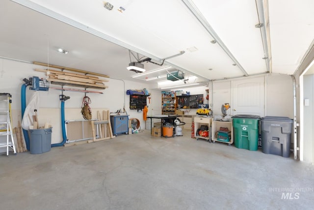 garage with a workshop area and a garage door opener