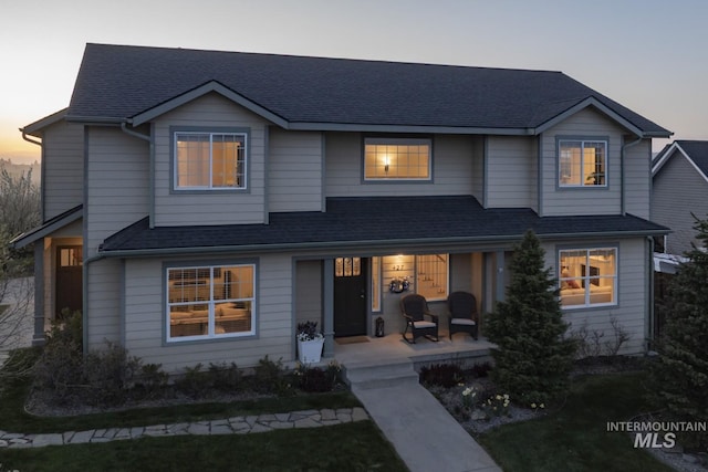 traditional home featuring roof with shingles