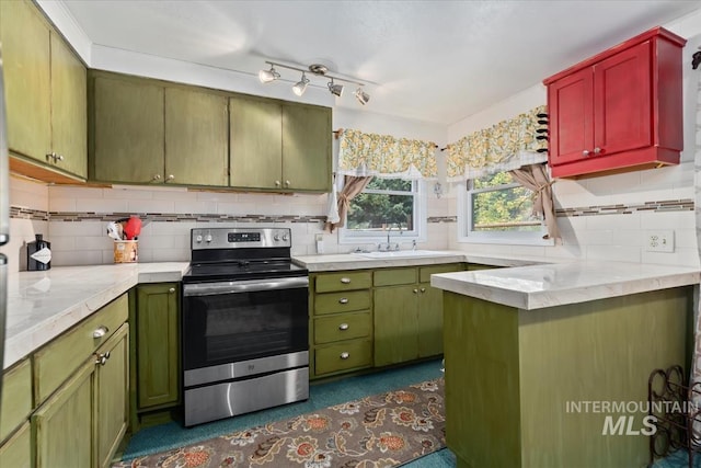 kitchen with a sink, electric stove, light countertops, backsplash, and green cabinetry