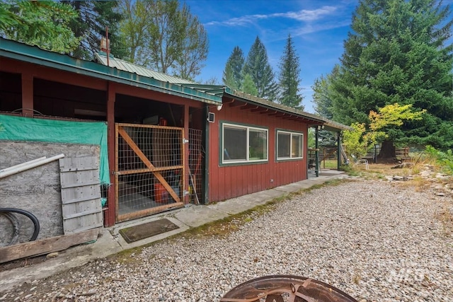 view of side of home with metal roof, an exterior structure, and an outdoor structure