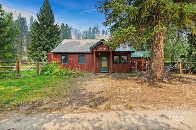 view of front facade featuring a front yard, metal roof, and fence