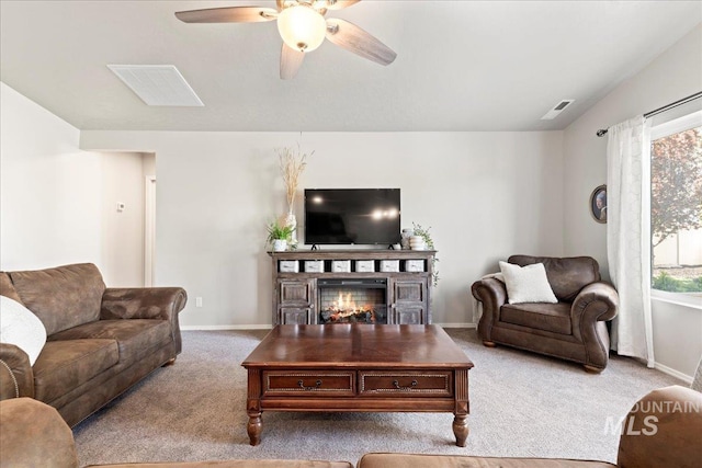 carpeted living area with ceiling fan, baseboards, plenty of natural light, and lofted ceiling