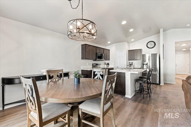 dining space featuring lofted ceiling, recessed lighting, a chandelier, light wood-style flooring, and baseboards