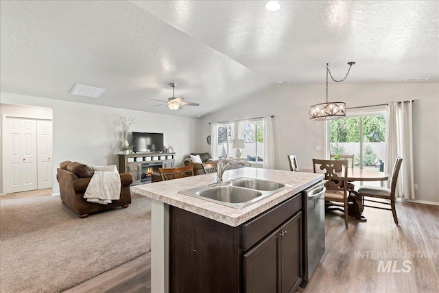 kitchen featuring a sink, lofted ceiling, dark brown cabinets, light countertops, and stainless steel dishwasher