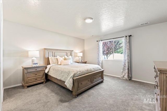 bedroom featuring a textured ceiling, light carpet, and baseboards