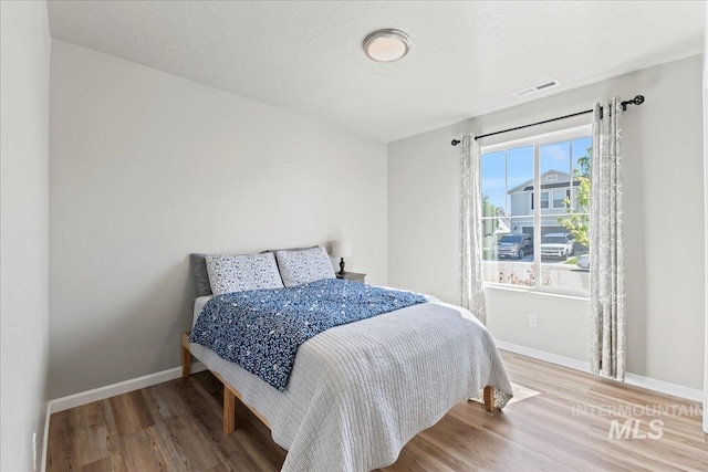 bedroom featuring baseboards and wood finished floors