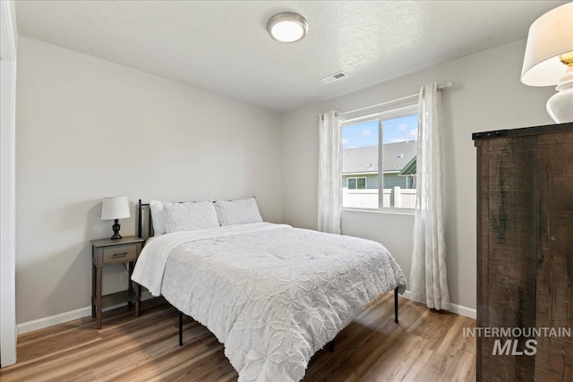 bedroom featuring wood finished floors and baseboards