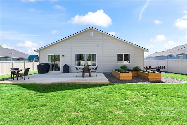 back of house featuring a vegetable garden and a patio area