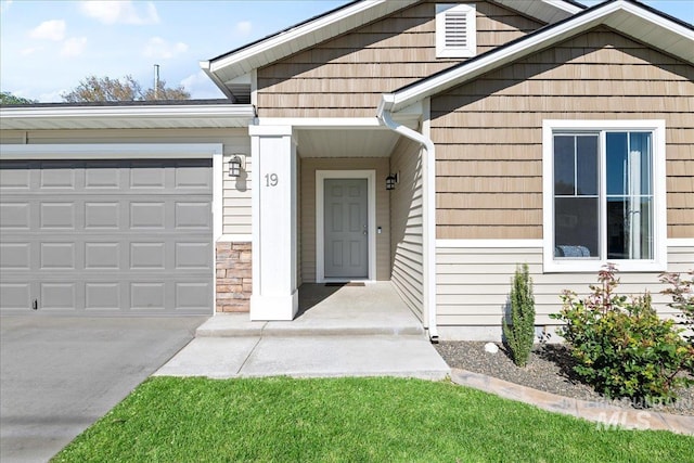 property entrance featuring concrete driveway and a garage