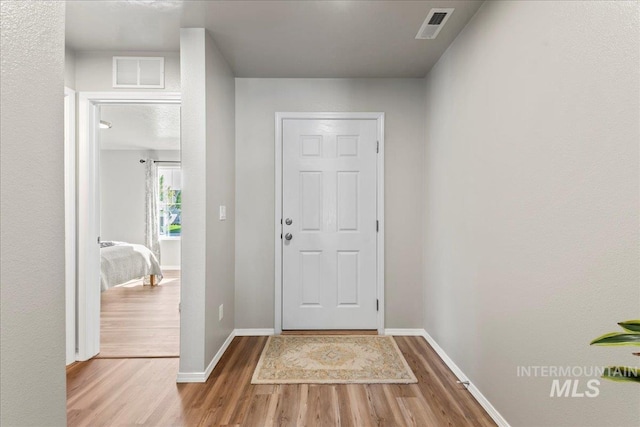 doorway to outside featuring wood finished floors and baseboards