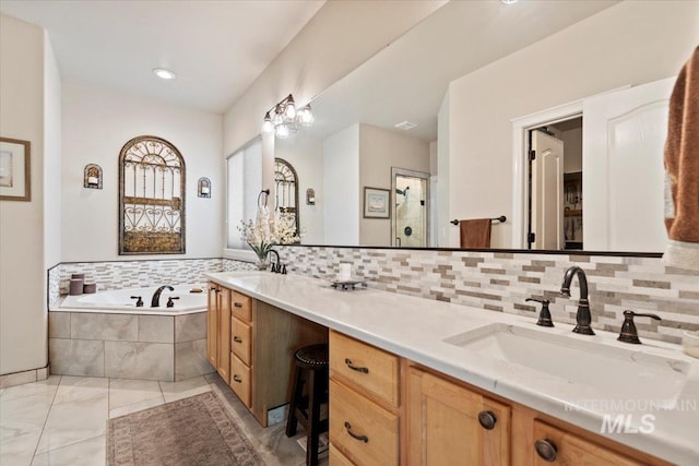bathroom with a bath, backsplash, double vanity, and a stall shower