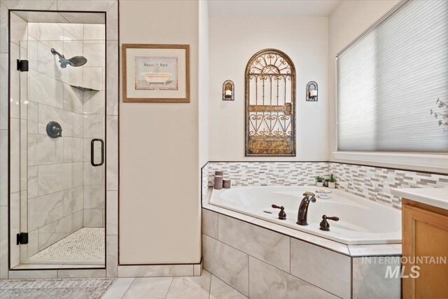 full bathroom with a bath, a shower stall, and vanity
