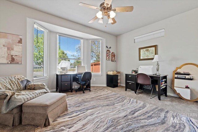 carpeted office space with baseboards and a ceiling fan