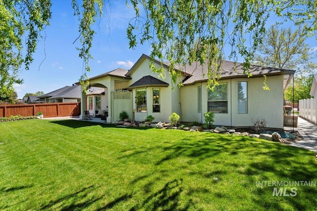 rear view of house featuring stucco siding, a patio area, and a shingled roof
