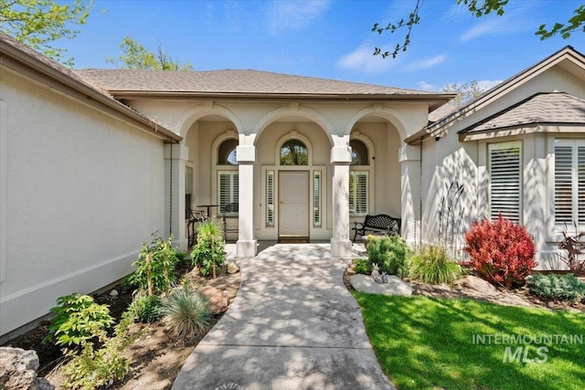 property entrance featuring a porch and stucco siding