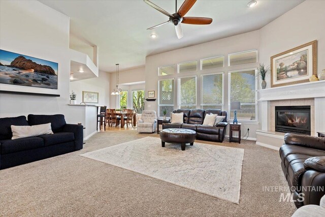 living area with carpet floors, a ceiling fan, baseboards, a glass covered fireplace, and recessed lighting