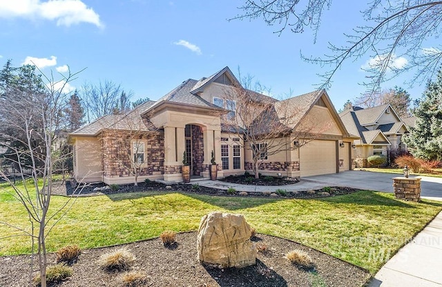 view of front of home with a garage, aphalt driveway, a front yard, and stucco siding