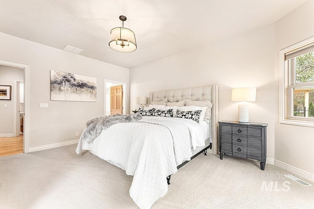 bedroom with baseboards, visible vents, and light colored carpet