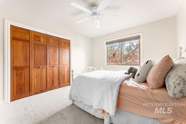 bedroom featuring light carpet, ceiling fan, and a textured ceiling