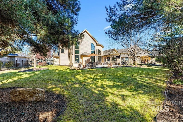 rear view of house featuring a patio area, fence, and a lawn