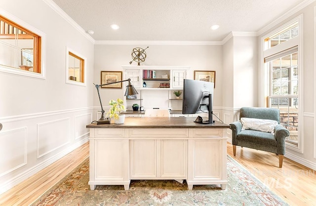 office with light wood-style floors, crown molding, a decorative wall, and a textured ceiling