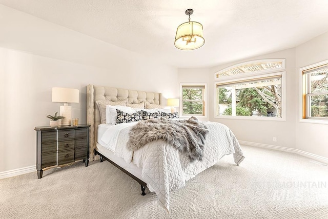 carpeted bedroom featuring a textured ceiling and baseboards