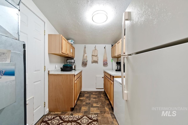 12456 S Lonnie Ln, Kuna, ID 83634 - kitchen with freestanding refrigerator, stone finish flooring, light countertops, a textured ceiling, and stainless steel fridge