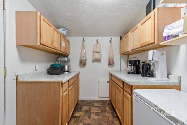12456 S Lonnie Ln, Kuna, ID 83634 - kitchen featuring light countertops, stone finish flooring, a textured ceiling, refrigerator, and baseboards