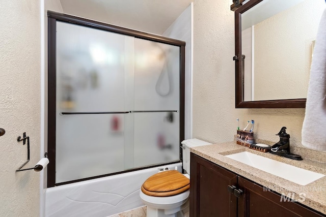 12456 S Lonnie Ln, Kuna, ID 83634 - full bath with a textured wall, toilet, vanity, and bath / shower combo with glass door