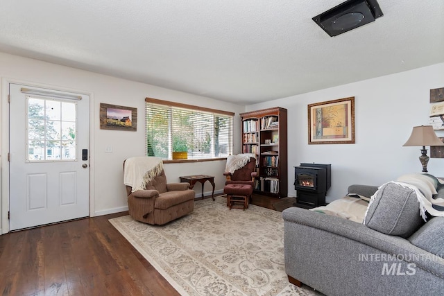 12456 S Lonnie Ln, Kuna, ID 83634 - living area with a wood stove, healthy amount of natural light, wood finished floors, a textured ceiling, and baseboards