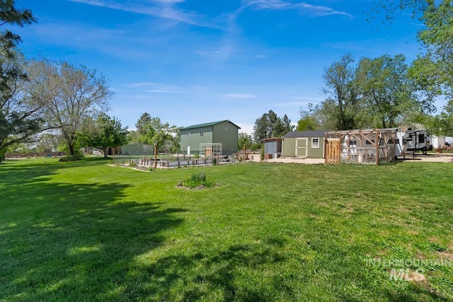 12456 S Lonnie Ln, Kuna, ID 83634 - view of grassy yard featuring an outbuilding, exterior structure, and a vegetable garden