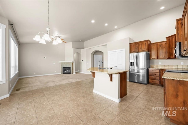 18555 N Goldenridge Pl, Boise, ID 83714 - kitchen with a chandelier, stainless steel appliances, light stone countertops, and arched walkways